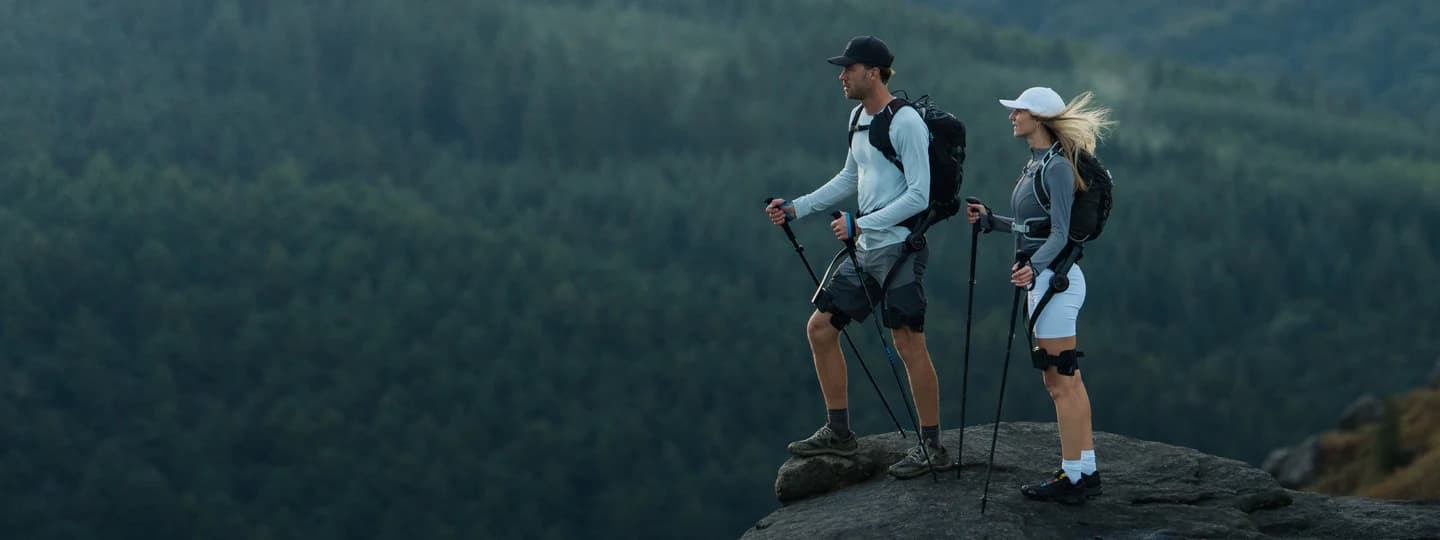 Two hikers wearing Hypershell exoskeletons standing on a rocky overlook